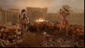 Two bandits standing next to a brazier that's lit in a ruined city above the Wellspring in Outriders New Horizon. There is a sandstorm.