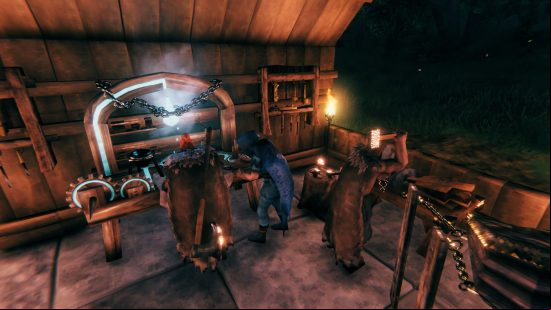 Best crafting games: Two player characters are bent over a crafting station in Valheim