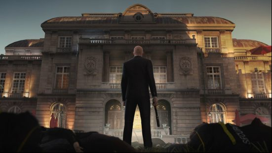 Best PC games - Hitman: Agent 47 standing in front of a huge building with his pistol