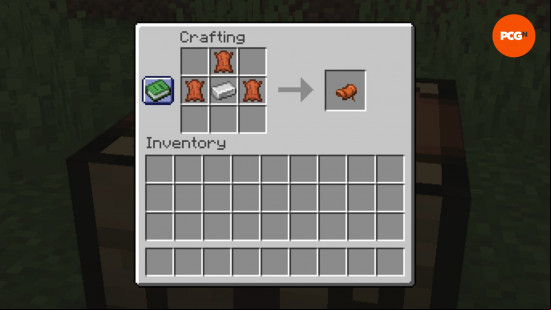 The Minecraft saddle crafting recipe in a crafting table, consisting of three leather and one iron ingot.