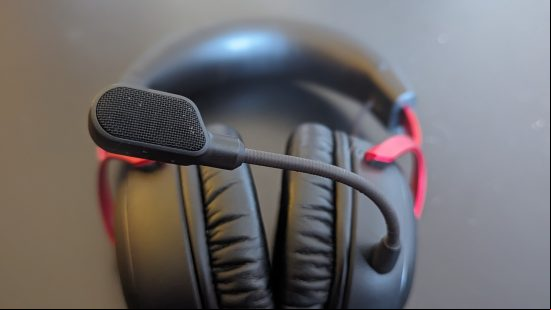 HyperX Cloud 3 review: a black and red headset is sat on a black table, with the microphone in sharp focus near the camera.