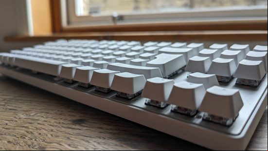 Logitech G Pro X TKL Lightspeed review: a white keyboard appears side on above a wooden worktop.