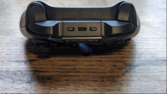Asus ROG Raikiri Pro review: a black controller appears on a wooden desk with the top of the controller pointing to camera.
