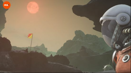 An astronaut in The Invincible looking up at at the sun with a tattered flag on a cliff below.