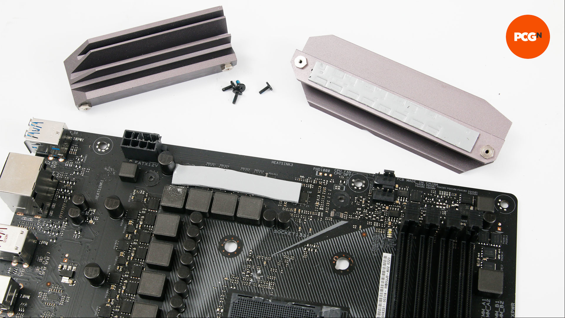 Heatsinks removed from a motherboard sit on a table ready for painting