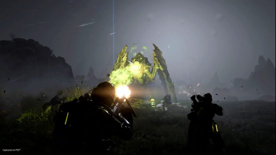 Helldivers 2 - Marines shoot at a large bug on a rocky, alien planet.