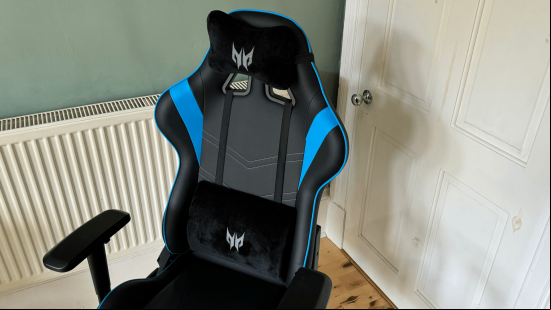 A black and blue gaming chair with detatchable lumbar and neck 