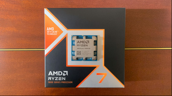 AMD Ryzen 7 9800X3D review: Gaming U on top of box with wooden background.